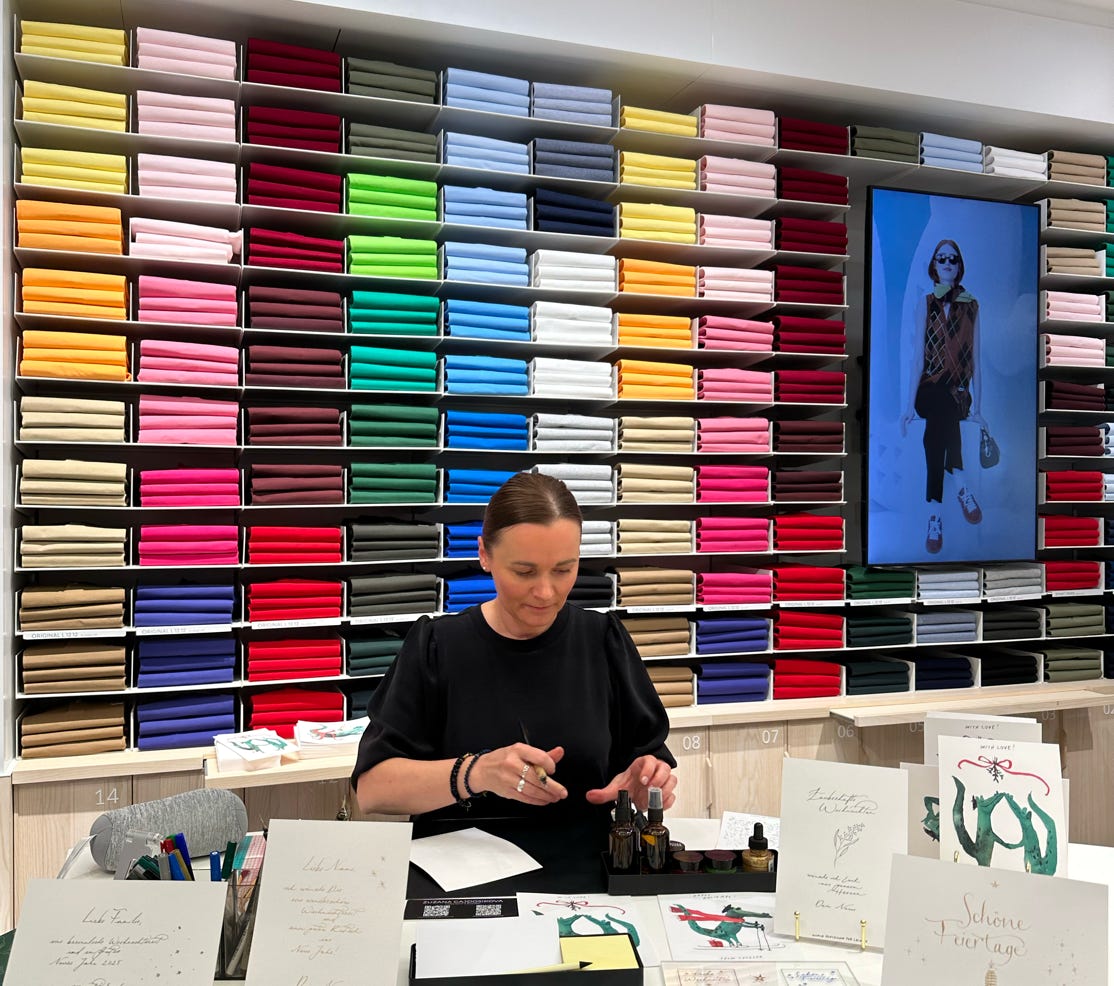 Event Kalligrafie bei Lacoste. Handgeschriebene Namen und Texte auf Karten und Parfümflaschen.